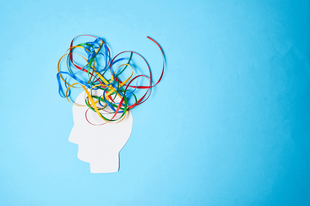 A mental health image. It is blue image with a white image of a human head. It has colourful ribbons coming out of it to show thoughts in your mind.