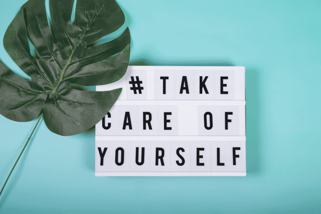 Mental Health Image. A light blue background with a big green leaf. Next to it is a white board with the words "Take care of yourself" on it
