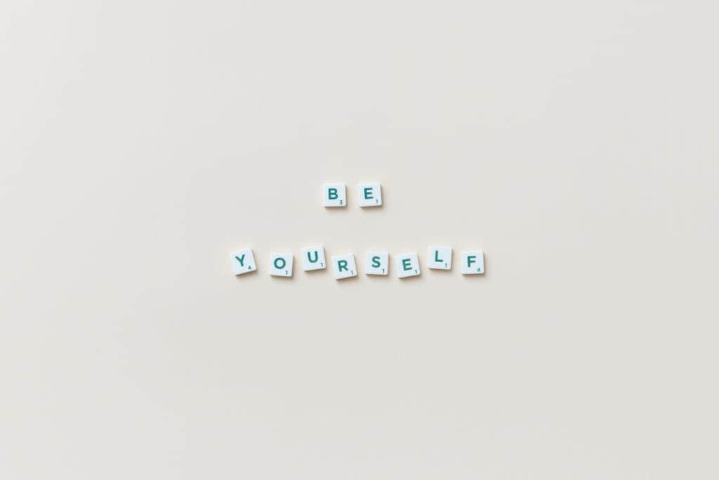 Motivational phrase "Be Yourself" spelled with letter tiles on a white background.